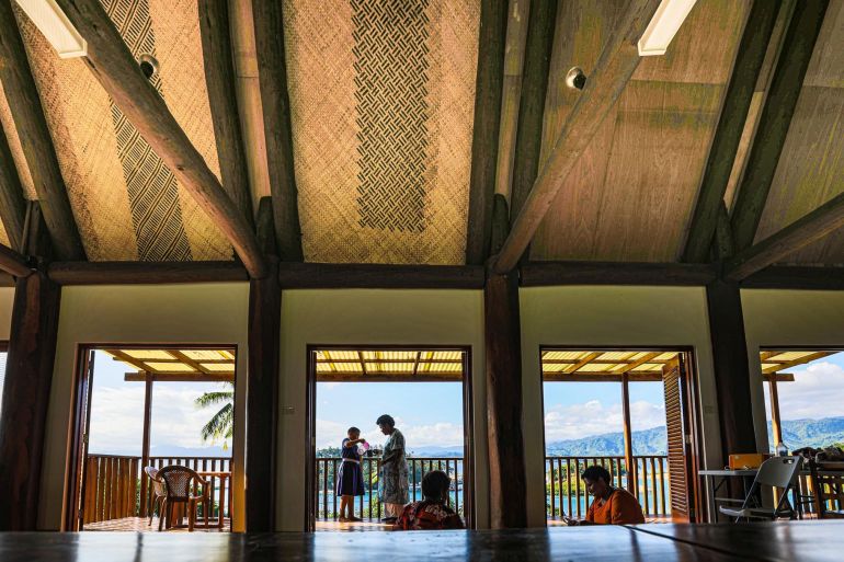 A view from inside the Cakaudrove Women's Centre looking out to the sea. The roof is made of traditional materials. The ceiling is high and airy. There is a sense of light and space.