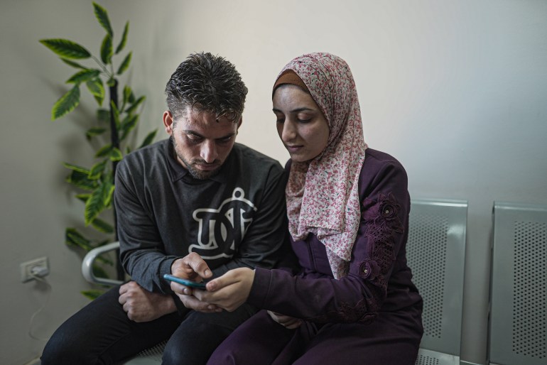 Noor and her husband Reyhan look at photos of their baby boy on her phone, who they have not seen for weeks 