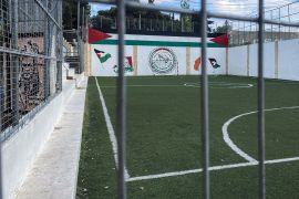 A view of an empty Lajee Celtic pitch with Palestinian flag murals on the far wall