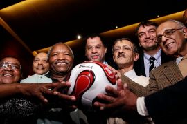 FIFA officials with former Robben Island prisoners holding a ball autographed by former South African President Nelson Mandela [File: Gianluigi Guercia/AFP]