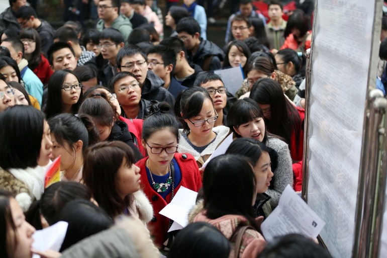 This picture taken on November 24, 2013 shows a group of candidates arriving for China's national civil service exam in a university in Nanjing, east China's Jiangsu province. More than one million people took China's national civil service exam on November 24, officials said, but faced huge odds against clinching one of the few government jobs available. CHINA OUT AFP PHOTO (Photo by AFP)