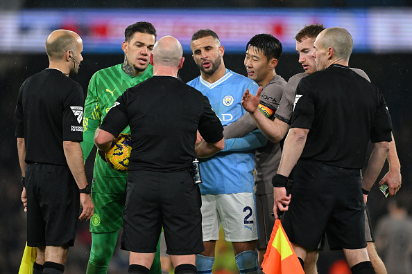 Ederson and Kyle Walker of Manchester City talk to Referee, Simon Hooper during the match.