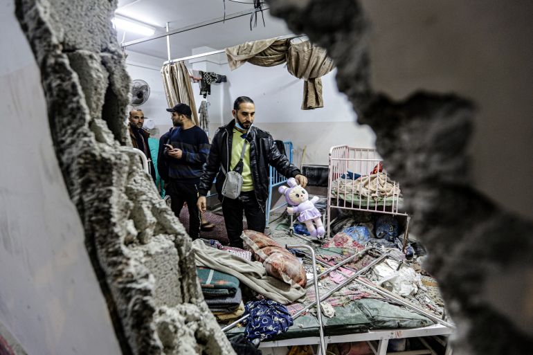 People inspect the damage in a room following Israeli bombardment at Nasser hospital in Khan Younis in the southern Gaza Strip on December 17, 2023. [STRINGER / AFP]