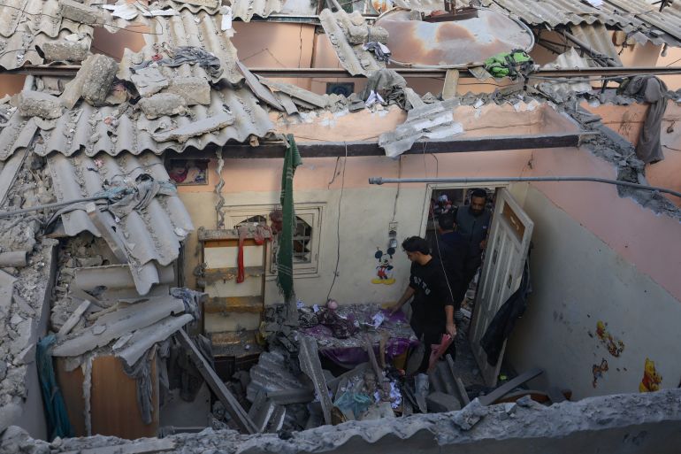 Palestinos verificam os danos de uma casa destruída em um ataque israelense a Khan Yunis, no sul da Faixa de Gaza, em 1º de dezembro de 2023, após o término da trégua de sete dias [MAHMUD HAMS / AFP]
