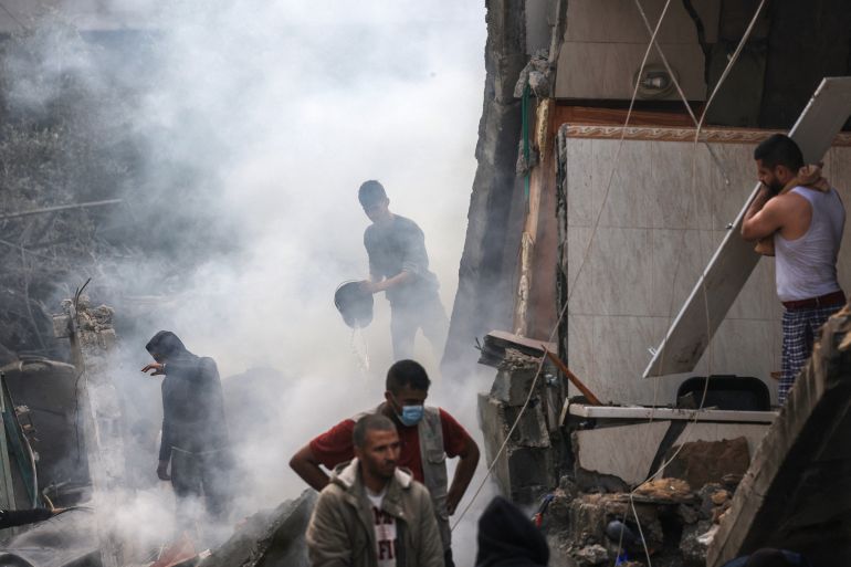 Palestinos reagem em meio aos escombros de edifícios destruídos após o bombardeio israelense em 14 de dezembro de 2023 em Rafah, no sul da Faixa de Gaza. [MAHMUD HAMS / AFP]