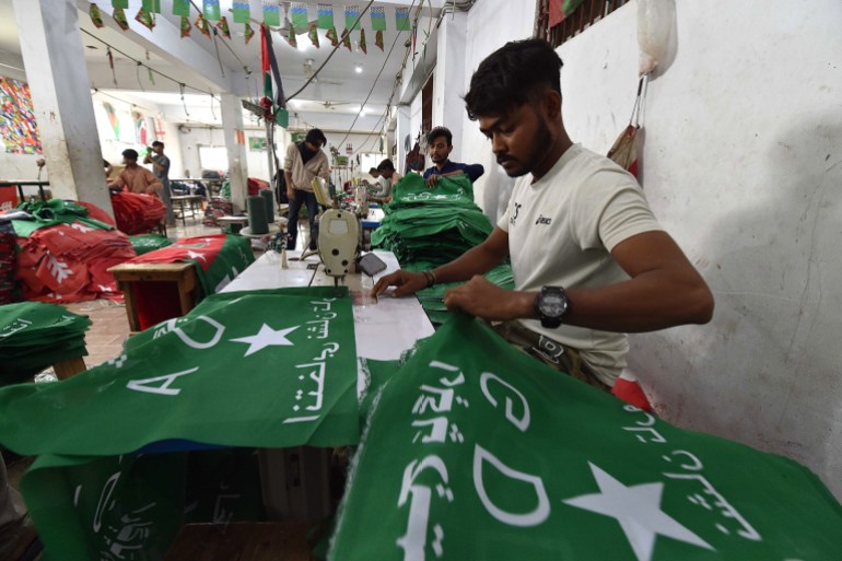Trabalhadores paquistaneses preparando bandeiras do partido enquanto o país se prepara para as eleições gerais.  (Shahzaib Akber/EPA)