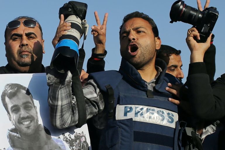Journalists take part in a protest against the killing of Palestinian journalist Yasser Murtaja