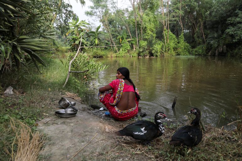 Ashtami Mondal, 30, whose 31-year-old husband Haripada died in a tiger attack, cleans utensils in a pond next to her home on the island of Kumirmari in the Sundarbans, India, November 19, 2020. Climate change is leaving less and less of the Sundarbans habitable