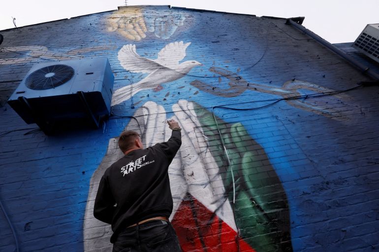 L'artista di strada Nathan Murdoch crea un'opera d'arte a sostegno dell'Ucraina e della Palestina, a Peterborough, Gran Bretagna, il 15 marzo 2022. REUTERS/Andrew Couldridge IMMAGINI TPX DEL GIORNO
