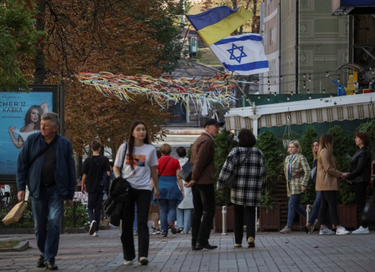 Una bandiera israeliana sventola accanto a una bandiera ucraina, a sostegno di Israele, nel conflitto in corso tra Israele e il gruppo islamista palestinese Hamas e nel mezzo dell'attacco della Russia all'Ucraina, nel centro di Kiev, Ucraina, il 14 ottobre 2023. REUTERS/Gleb Garanich