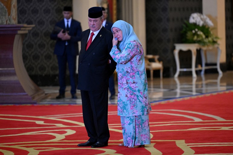 Le sultan de Johor avec sa sœur, Tunku Azizah Aminah Maimunah Iskandariah, après avoir été choisi comme prochain roi.  Tunku Azizah, alors reine de Malaisie, lui serre le bras.
