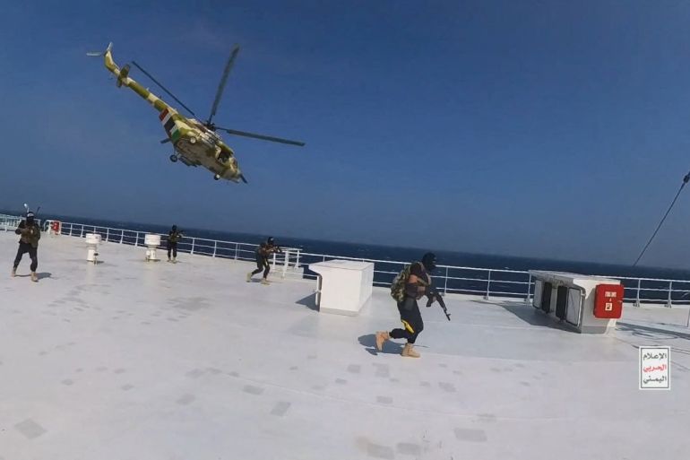 Houthi military helicopter hovers over the Galaxy Leader cargo ship as Houthi fighters walk on the ship's deck in the Red Sea in this photo released November 20, 2023