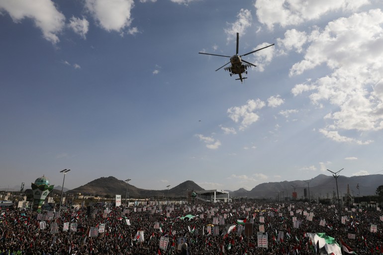Um helicóptero voa enquanto apoiadores Houthi se reúnem para comemorar os dez combatentes Houthi mortos pela Marinha dos EUA no Mar Vermelho, em Sanaa, Iêmen, 5 de janeiro de 2024. REUTERS/Khaled Abdullah
