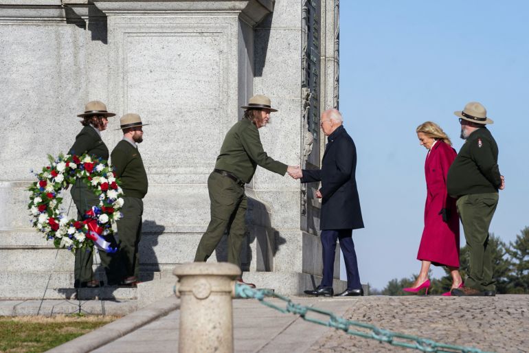 U.S. President Joe Biden greets personnel as U.S. first lady Jill Biden walks while attending a memorial wreath ceremony at Valley Forge National Arch, in Valley Forge, Pennsylvania, U.S., January 5, 2024. 