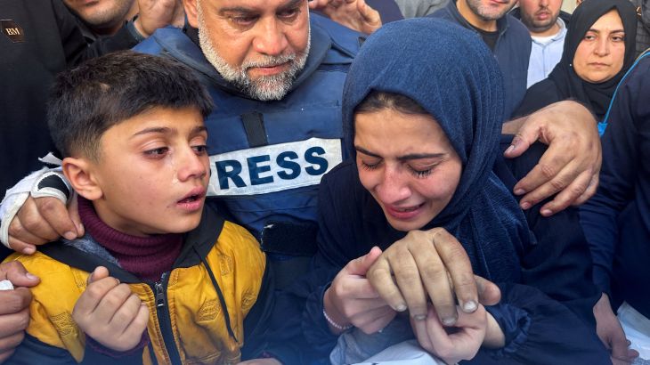 Al Jazeera journalist Wael Dahdouh hugs his daughter and son as they attend the funeral of his son Hamza, also a journalist, after he was killed in an Israeli attack