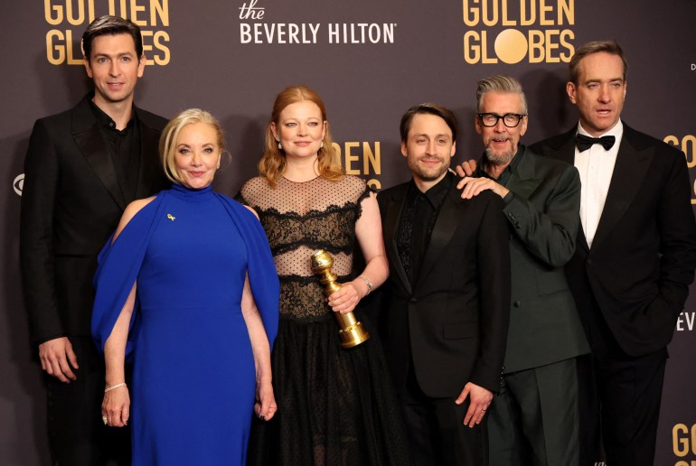 The cast of Succession including Sarah Snook, Mathew Macfadyen and Kieran Culkin. Snook is holding the Golden Globe