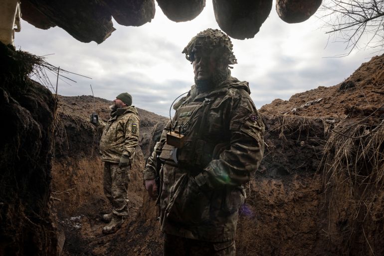 Ukraynalı askeri mühendisler, Rusya'nın 28 Aralık 2023'te Ukrayna'ya saldırısının ortasında, birliklerinin Kupiansk dışındaki ön hatlara yakın yeni tahkimat sisteminin bir parçası olarak inşa ettiği yeni kazılmış bir siperde duruyor. REUTERS/Thomas Peter