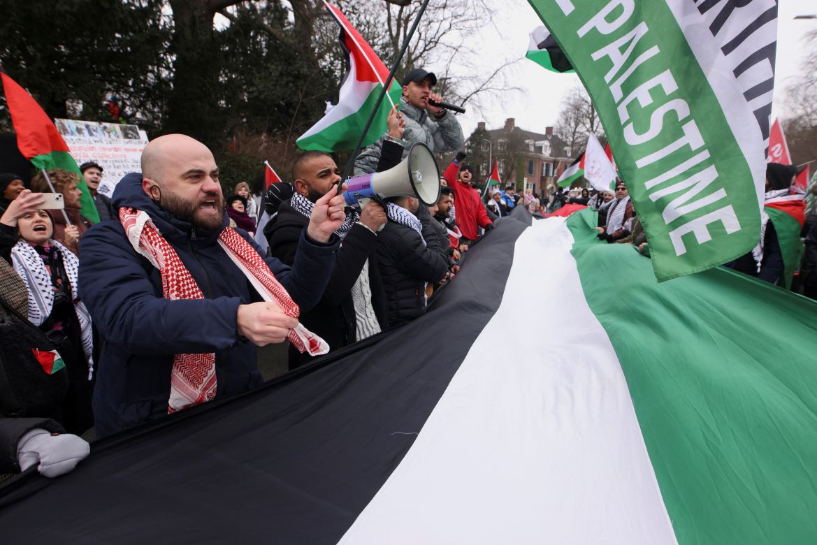 Pro-Palestinian demonstrators hold Palestinian flags as they protest near the International Court of Justice (ICJ
