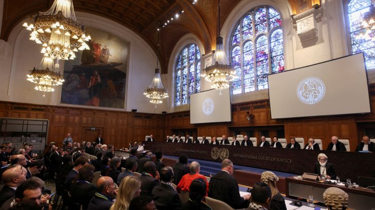 People sit inside the International Court of Justice