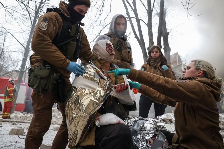 Medical workers treat a wounded local resident at a site of residential buildings heavily damaged during a Russian missile attack