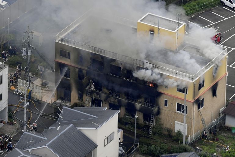 Firefighters battling fires at the site where a man started a fire after spraying a liquid at a three-story studio of Kyoto Animation Co