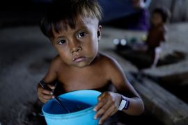 A Yanomami child is fed while receiving healthcare in an accommodation used to shelter the sick, at the healthcare unit of the Auaris Base Hub, in Yanomami Indigenous land, Roraima state, Brazil, on January 10, 2024 [Reuters/Ueslei Marcelino]