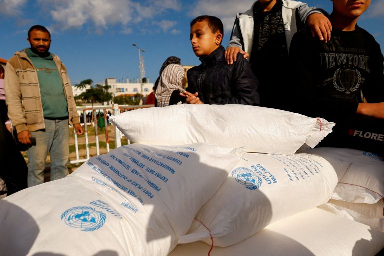 Palestinians receive flour bags distributed by UNRWA in Rafah, in the southern Gaza Strip November 21, 2023