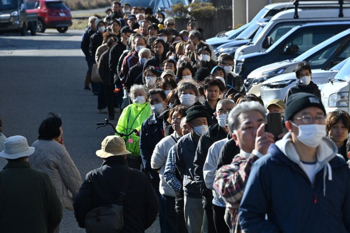 People queue around the Shika Town hall as they wait to receive water at a distribution point in Shika, Ishikawa prefecture.