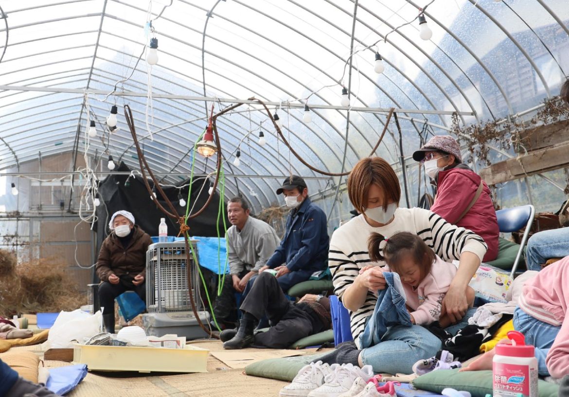 Residents shelter inside a plastic greenhouse after being evacuated in the city of Wajima, Ishikawa Prefecture.