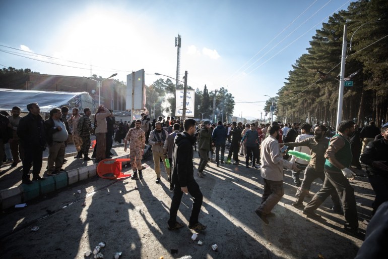 Pessoas se dispersam perto do local onde duas explosões em rápida sucessão atingiram uma multidão marcando o aniversário do assassinato do general da Guarda Qasem Soleimani em 2020, perto da mesquita Saheb al-Zaman, na cidade de Kerman, no sul do Irã.