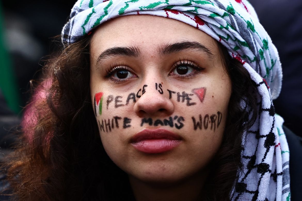 A Pro-Palestinian supporter with a message reading "Peace is the white man's word" written on her face take part in a demonstration in central London on January 6