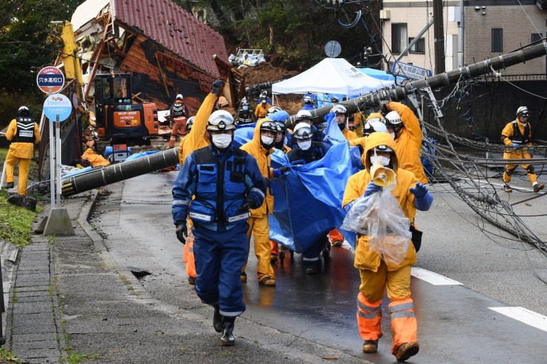 Rescuers carry away the body of victim who was retrieved from a landslide site in the Kawashima district in the city of Anamizu, Ishikawa Prefecture, on January 6, 2024, after a major 7.5 magnitude earthquake struck the Noto region on New Year's Day.