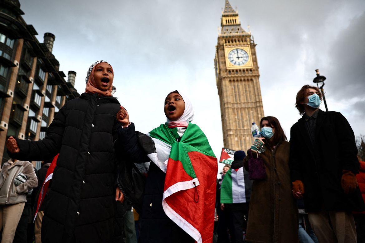 Two young girls, one wrapped in a Palestinian flag, chants slogans as they take part in Pro-Palestinian demonstration, in front of The Elizabeth Tower, commonly known by the name of the clock's bell, "Big Ben", at the Palace of Westminster, home to the Houses of Parliament, in central London on January 6