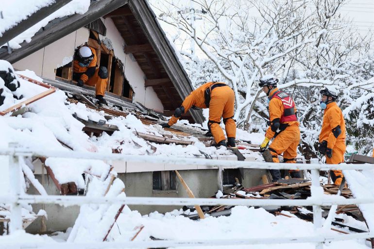A rescue team searching for survivors on the snow-covered ruins of a house