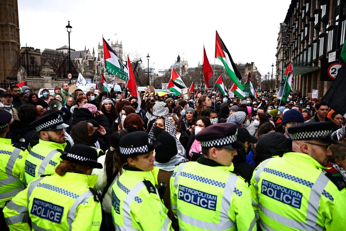Metropolitan (MET) Police officers stand in front of Pro-Palestinian protesters during a demonstration in central London on January 6, 2024, calling for a ceasefire now in the war in Gaza. - Thousands of civilians, both Palestinians and Israelis, have died since October 7