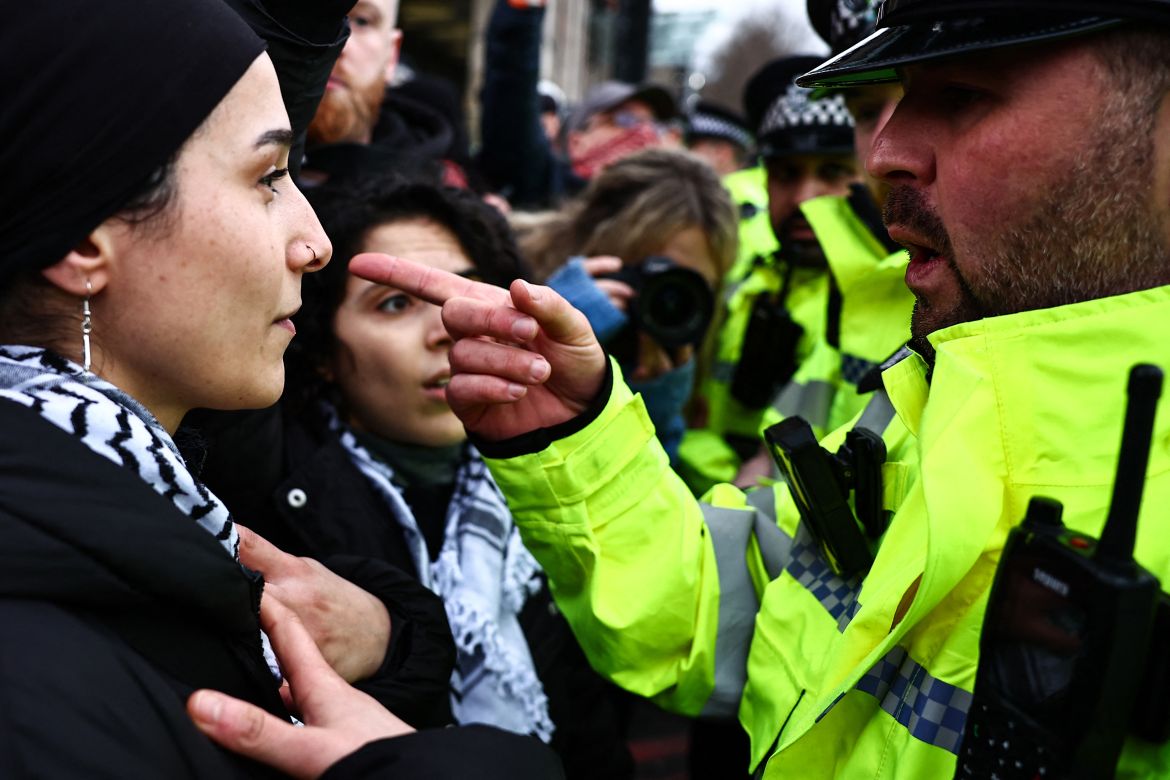 A Metropolitan (MET) Police officer speaks and gestures towards a Pro-Palestinian supporter during a demonstration in central London on January 6