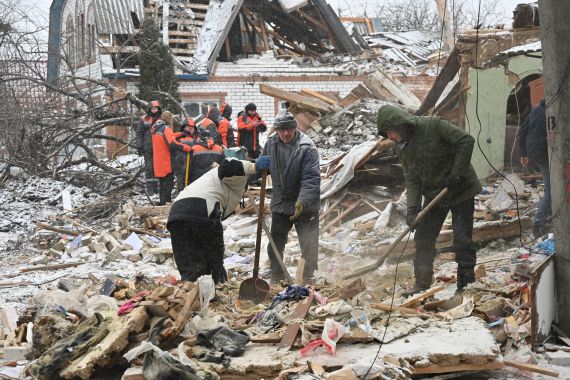 Rescuers and local residents clear debris following Russian strikes, in Zmiiv, Kharkiv region