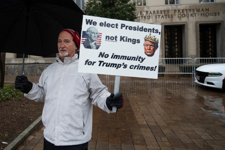 Protesters stands outside the E. Barrett Prettyman US Courthouse in Washington, DC