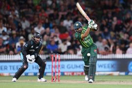 Pakistan's Babar Azam bats while being watched by New Zealand wicketkeeper Devon Conway (L) during the second Twenty20 international cricket match between New Zealand and Pakistan at Seddon Park in Hamilton on January 14, 2024. (Photo by MICHAEL BRADLEY / AFP)