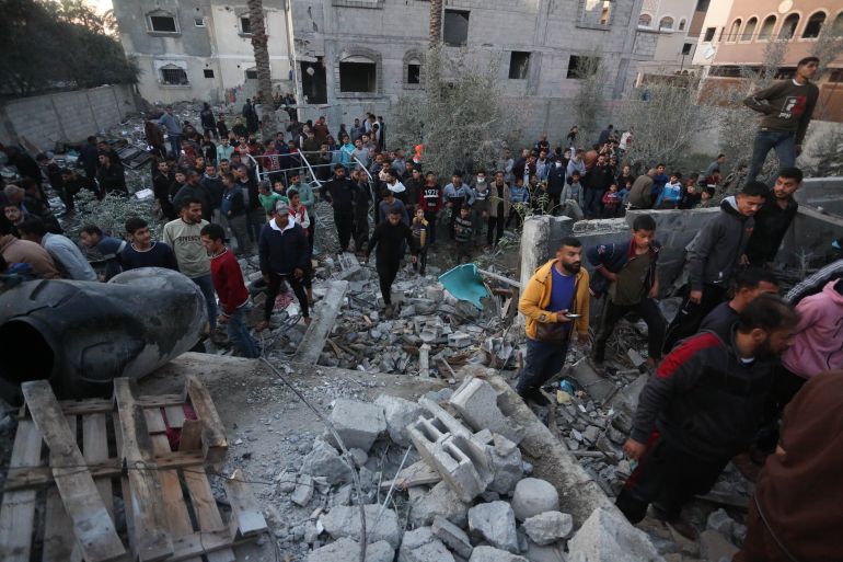 Residents and civil defense teams carry out a search and rescue operation around the rubble of the building demolished after Israeli attack in Deir al-Balah, Gaza, on January 05, 2024.