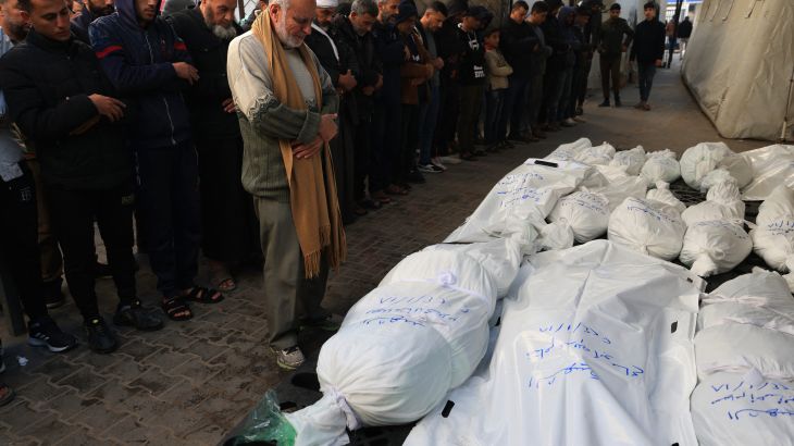 Palestinians mourn over bodies of victims of Israeli bombardment on January 18