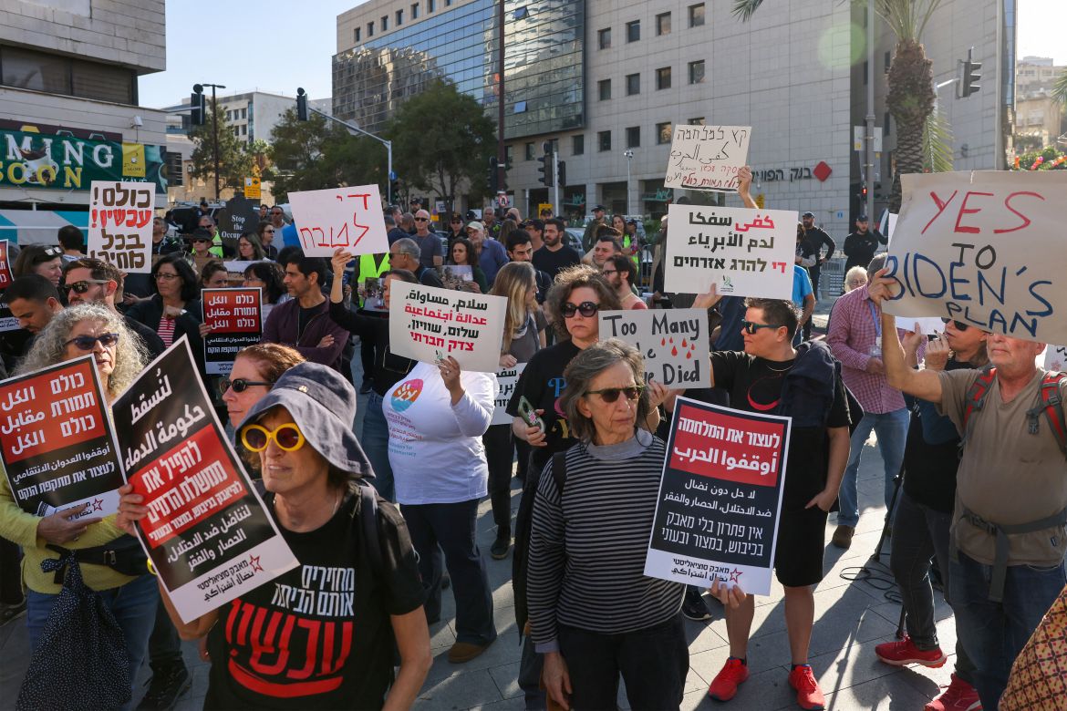 People hold placards as they take part in a protest calling for a ceasefire and for the release of Israeli hostages held in Gaza