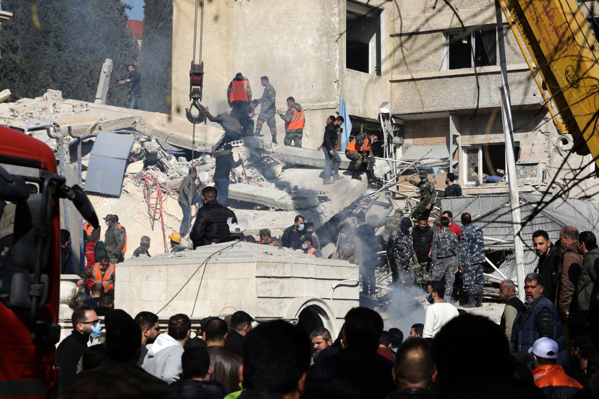 Security and emergency personnel search the rubble of a building destroyed in a reported Israeli strike in Damascus on January 20