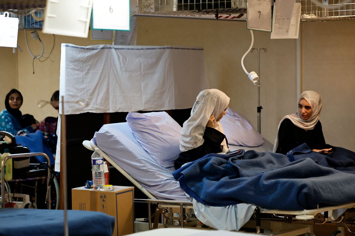 Wounded Palestinian young women talk on their beds as they receive medical care onboard the French LHD Dixmude military ship