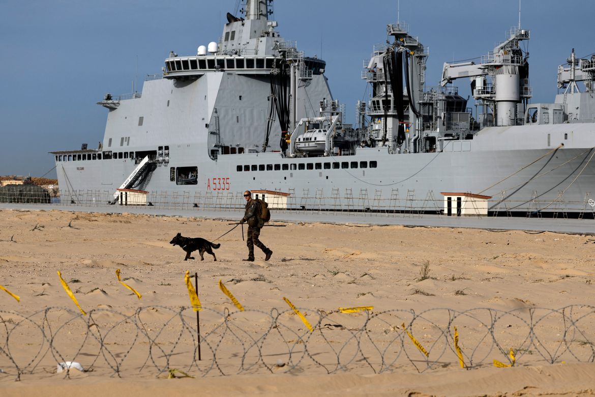 A French soldier and his dog patrols in front of the French LHD Dixmude military ship, which serves as a hospital to treat wounded Palestinians, as it docks at the Egyptian port of Al-Arish on January 21