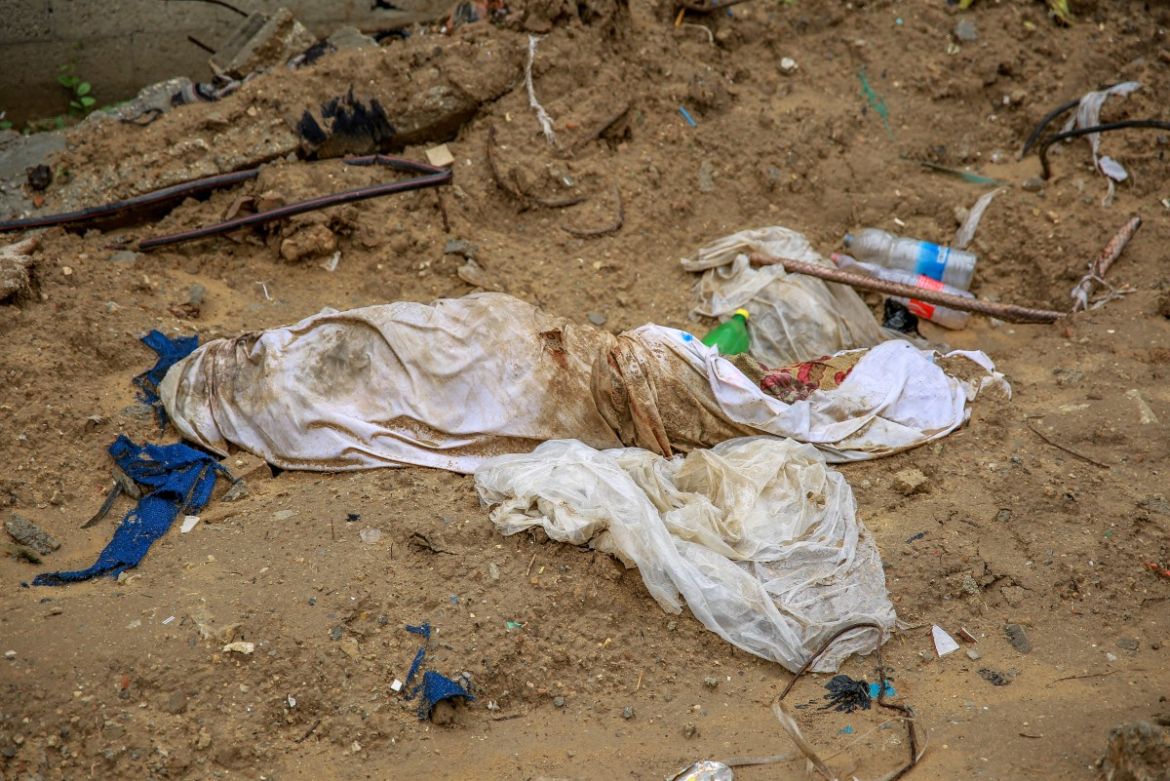 Shrouds containing human remains lie in the mud at a makeshift cemetery, parts of which the Israeli army reportedly bulldozed to exhume bodies, in the eastern al-Tuffah neighbourhood of Gaza City
