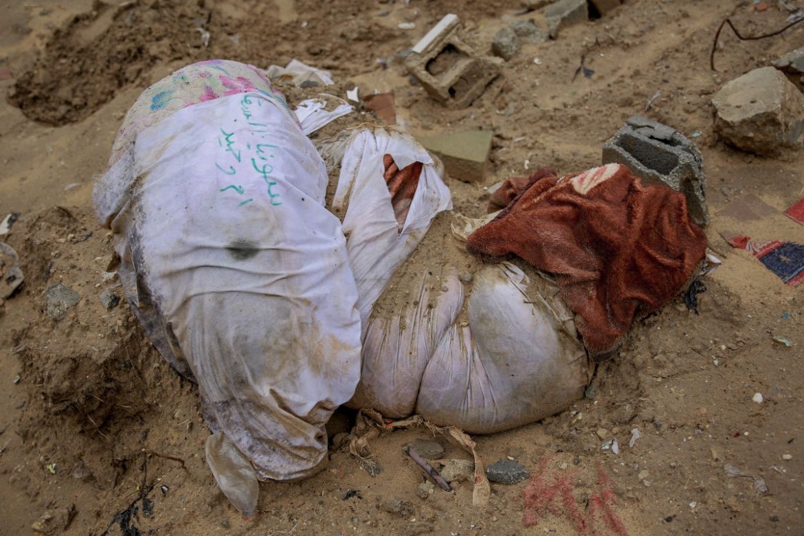 EDITORS NOTE: Graphic content / Shrouds containing human remains lie in the mud at a makeshift cemetery, parts of which the Israeli army reportedly bulldozed to exhume bodies, in the eastern al-Tuffah neighbourhood of Gaza City
