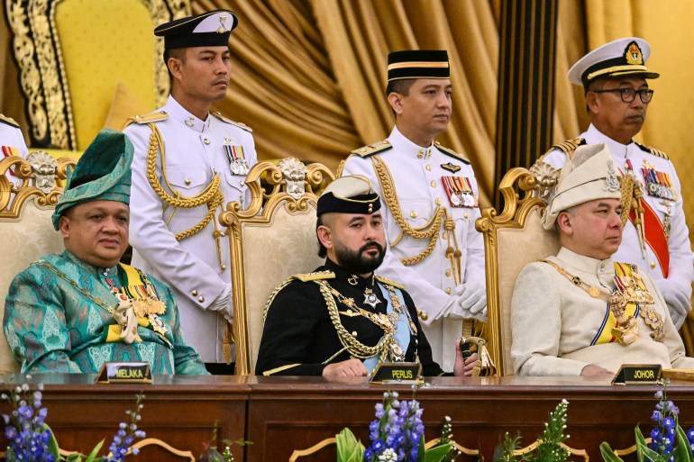 Johorlu Veliaht Prens İsmail Sultan İbrahim, babasının yerleştirme töreninde.  Perlis ve Perak hükümdarlarının arasında oturuyor