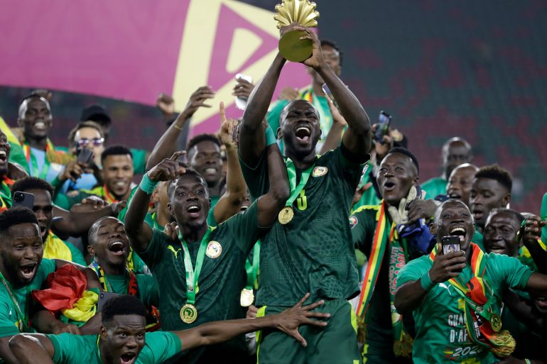 FILE - Senegal's players celebrate with the trophy after winning the African Cup of Nations 2022 final soccer match between Senegal and Egypt at the Ahmadou Ahidjo stadium in Yaounde, Cameroon, on Feb. 6, 2022. (AP Photo/Sunday Alamba, File)