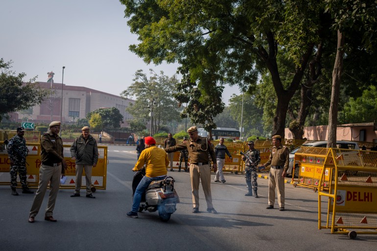 Delhi police officers asks a motorist to stop for checking at a checkpoint set up outside the Indian parliament in New Delhi, India